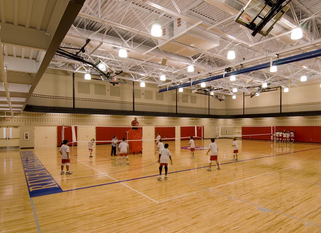 Indoor gymnasium with students playing volleyball